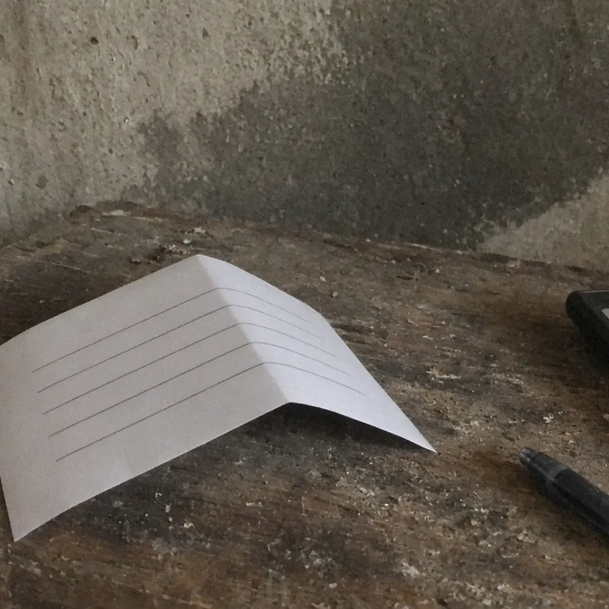 Paper estimate on a basement workbench beside a calculator